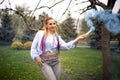 A bright girl with glitter makeup and African braids in a bluish shirt takes refuge in artificial smoke in a park full Royalty Free Stock Photo