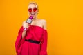 Bright girl in a red dress with bare shoulders sings with a microphone