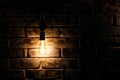 Bright glowing light bulb hangs near old grunge brick wall Royalty Free Stock Photo