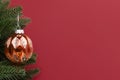 Bright gold Christmas bauble hanging on a fir branch. Royalty Free Stock Photo