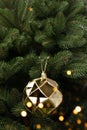 Bright gold colored Christmas bauble hanging on a fir branch. Royalty Free Stock Photo