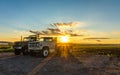 Bright gold sunset shines on heavy duty trucks and farmlands