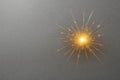 A bright golden spark on a dark gray background. Space for text. Royalty Free Stock Photo