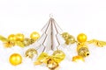 Bright golden Xmas decorations ribbons, baubles, bows, ornament, fir tree on white artificial snow background with copy space. Royalty Free Stock Photo