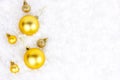 Bright golden Xmas decorations ribbons, baubles, ornament flat lay on white artificial snow background with copy space Royalty Free Stock Photo