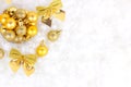 Bright golden and yellow Christmas decorations ribbons, baubles, ornament flat lay on white artificial snow background with copy Royalty Free Stock Photo