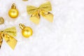Bright golden and yellow Christmas decorations ribbons, baubles, ornament flat lay on white artificial snow background with copy Royalty Free Stock Photo