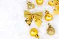 Bright golden and yellow Christmas decorations ribbons, baubles, ornament flat lay on white artificial snow background with copy Royalty Free Stock Photo