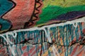 Bright graffiti on the wall. Colorful paint pattern on old cracked concrete wall. Watercolor background texture close up.