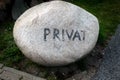 Bright granite erratic block with the faded inscription private to mark the end of the public area Royalty Free Stock Photo
