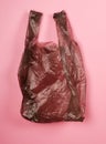 Bright gray plastic bag on red background. Royalty Free Stock Photo