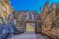 Bright Greek sunlight shines of rock wall of ancient Mycenae on the road up to the famous Lions Gate into the hill fortress where