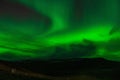 a bright green aurora bored light in the sky above a mountain