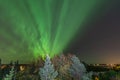 Bright green aurora lights almost on the whole sky over tree tops in Sweden, river, city lights and lake, clear skies with a lot Royalty Free Stock Photo