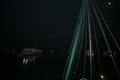 Bright green boat rigging  against the black of night sky with tourst boats lights reflecting of water in background Royalty Free Stock Photo