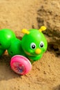 Bright green caterpillar toy in the sandbox. Royalty Free Stock Photo