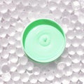 Bright green cream in circular container on clear gel beads background Royalty Free Stock Photo