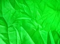 Bright green fabric texture with matted surfaces and folds for cloth background