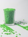 bright green masterbatch, in a glass cup on a white background. This polymer is a colorant in plastic industry products