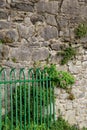 Bright green metal gate set against old stonewall Royalty Free Stock Photo