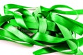 Bright green tangled satin ribbons on white. Royalty Free Stock Photo