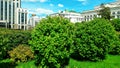 Bright green vegetation, round trees and shrubs, smart city architecture