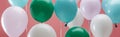 Bright green, white and blue party decorative balloons on pink background, panoramic shot. Royalty Free Stock Photo