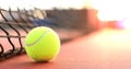 Bright greenish yellow tennis ball on clay court