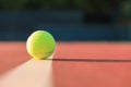 Bright greenish yellow tennis ball on the line Royalty Free Stock Photo