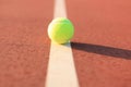 Bright greenish yellow tennis ball on the line Royalty Free Stock Photo