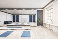 Bright group class in gym interior with yoga mats, wooden flooring, mirror with reflections, window with city view and