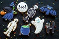 Bright halloween gingerbread cookies background with bat, witch, skeleton, ghost on black background top view