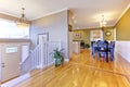 Bright hallway with hardwood floor. Open wall design with dining