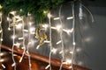 Bright hanging garland lights with wooden skates figure and fir branches