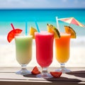 Bright healthy cocktails with fruits decorations and drinking straws on wooden table on tropical beach against blue sea Royalty Free Stock Photo