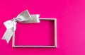 Bright holiday background. Empty frame and bow on pink background. Royalty Free Stock Photo