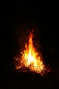 Bright huge flame in the darkness of nature. Summer bonfire at the campsite on a dark night Royalty Free Stock Photo