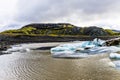 Bright ice burgs against the brown glacier fed lake at Hoffell Glacier Royalty Free Stock Photo