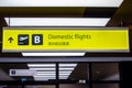 Bright illuminated yellow and black airport signs with arrows and plane icons and the title in Chinese: Domestic flights.