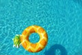Bright inflatable pineapple ring floating in swimming pool on sunny day Royalty Free Stock Photo