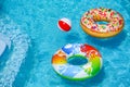 Bright inflatable rings and beach ball floating in swimming pool on sunny day Royalty Free Stock Photo