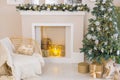 Bright interior with a faux fireplace decorated for Christmas. Christmas tree and armchair next to the fireplace.