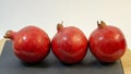 Bright juicy pomegranate fruits, white background, in the photo next three fruits are hardly placed Royalty Free Stock Photo