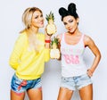 Bright juicy portrait of two cheerful girlfriends, having fun with slice pineapple and smiling. Casual style, bright