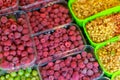 Bright juicy red raspberries in a plastic container on a store counter Royalty Free Stock Photo