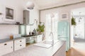 Kitchen interior with modern white furniture, pastel mint fridge and big floor to ceiling window