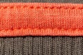 Bright knitted garment with seams, orange and gray. Copy space. Macro. Background.