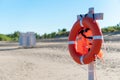 Bright lifebuoy and life jacket on the beach