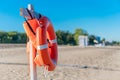 Bright lifebuoy and life jacket on the beach