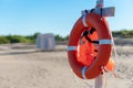 Bright lifebuoy and life jacket on the beach